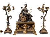 une statue représentant un homme assis sur une table, à côté de trois bougies