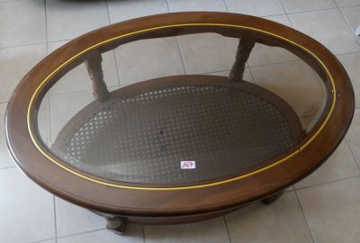 une table ronde avec un plateau en verre, posée sur un sol carrelé