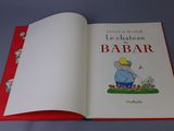 an open book with a picture of a man sitting on a bench