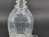 a clear glass bottle with a glass stopper next to it