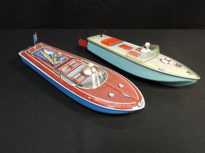 two toy boats sitting side by side on a black surface