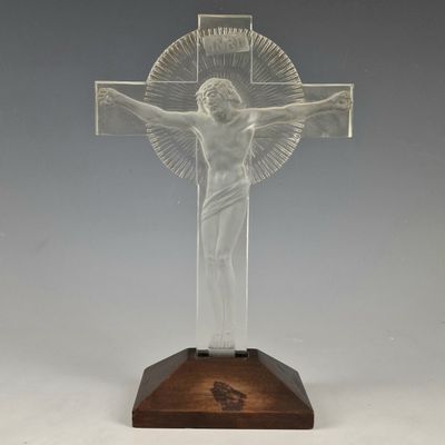 une image représentant un crucifix en verre transparent posé sur un socle en bois