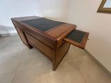a wooden desk with a glass top in a room
