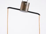 a metal object hanging from a string on a wall