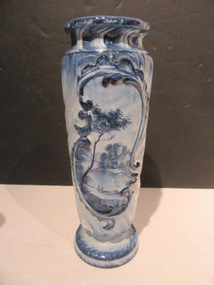 a blue and white vase sitting on a white table