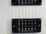 a close up of an electric guitar with a white body