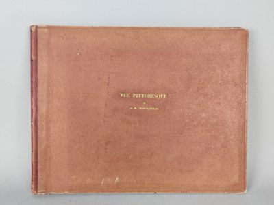 an old book with a brown cover sitting on top of a table