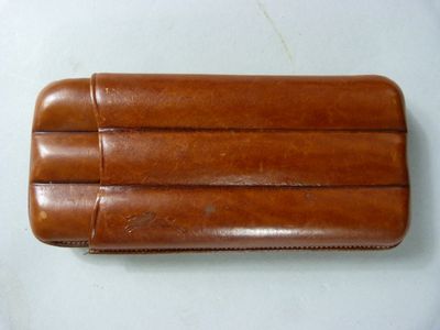 un étui en cuir marron posé sur une table blanche