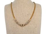 un collier à chaîne en or orné de pierres en cristal sur un mannequin