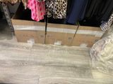 boxes of clothes are stacked on the floor in a clothing store