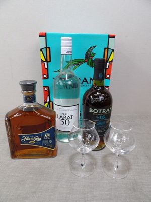 des bouteilles d'alcool, des verres et une caisse d'alcool posés sur une table