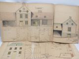 un livre ouvert sur lequel sont posés des dessins représentant une maison et des plans