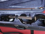 a violin in a case on a red table