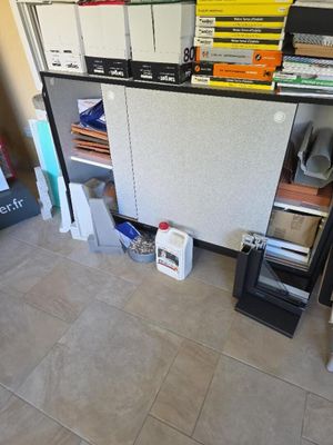 une pièce équipée d'un bureau, d'étagères et d'un réfrigérateur