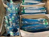 many toothbrushes in a cardboard box on the floor