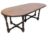 an oval dining table with turned legs and a wooden top