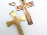 two gold crosses on a white surface one has a cross and the other has a cross on it