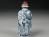 a small blue and white vase with a red lid