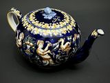 une théière bleue ornée d'un motif bleu et doré