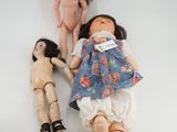 two dolls laying next to each other on a white surface