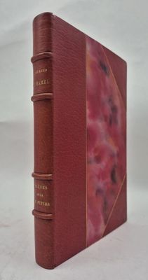 un vieux livre à la couverture rouge posé sur une surface blanche