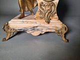 a statue of a woman holding a clock on top of a table