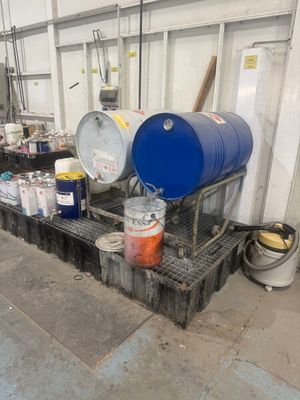 plusieurs fûts et seaux de peinture posés sur une étagère