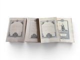 three open books sitting on top of each other on a white surface