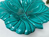 a green plate with a leaf shaped design on it