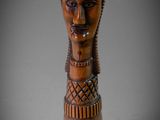 un gros plan sur une sculpture en bois représentant la tête d'une femme
