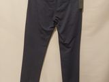 a pair of grey pants hanging on a hanger on a wall