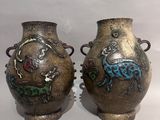 two vases with designs on them sitting on a white surface