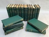 several green books stacked on top of each other on a white surface