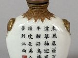 a white and gold vase with chinese writing on it