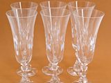 four empty wine glasses are lined up on a brown surface