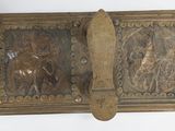 an old brass belt with a picture of a man and a woman on it