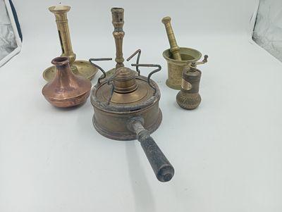 quatre types différents d'objets en laiton posés sur une table blanche