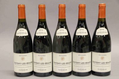 six bouteilles de vin sont alignées sur une table