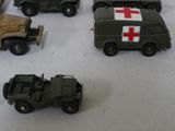 several toy army vehicles are lined up on a white surface
