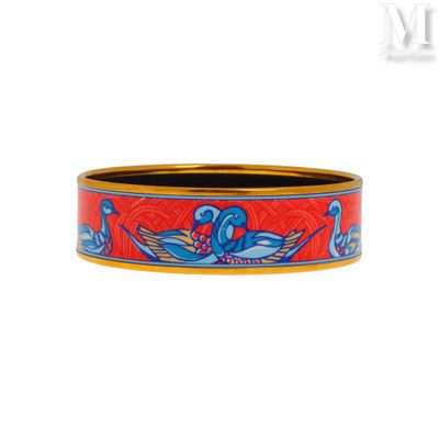 un gros plan sur un bracelet rouge et bleu orné d'un oiseau