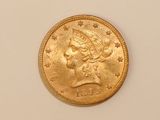 a close up of a gold coin on a white surface