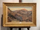 une peinture à l'huile représentant une chaîne de montagnes, dans un cadre doré