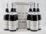 three bottles of red wine sit in front of a white box