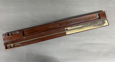 une vieille règle en bois surmontée d'une plaque en laiton