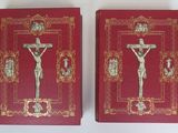 deux livres rouges aux bords dorés, ornés d'un crucifix