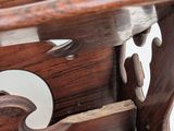 a close up of a wooden bench with a mirror on the back of it