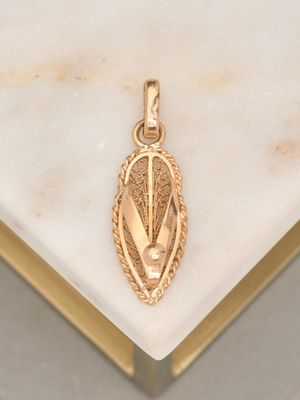 an image of a gold pendant on a marble surface