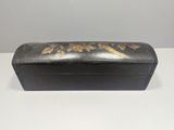 an old black box with gold flowers on it sitting on a table