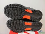 the soles of a pair of black and orange running shoes
