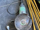 a drill on the floor next to a pile of tools